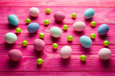 Colored Easter eggs and green balls on pink wooden backgroundの写真素材