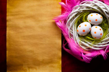 Three white Easter eggs in the nest and blank handmade paper sheetの写真素材
