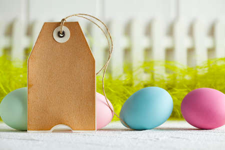 Colored Easter eggs and blank paper label on abstract backgrondの写真素材