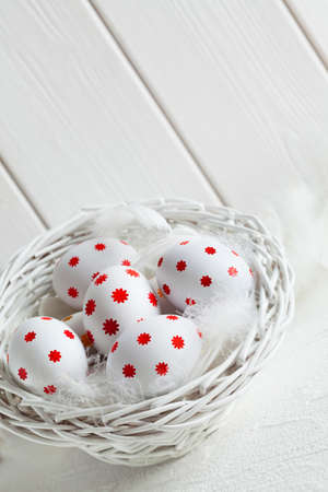 Easter eggs in white basket on white backgroundの写真素材