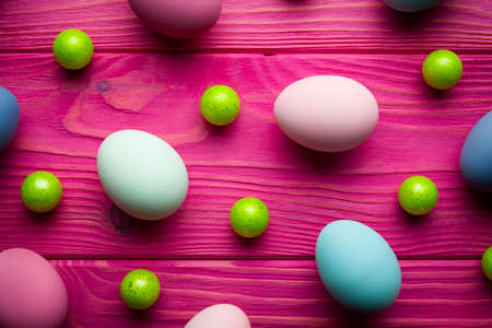 Colored Easter eggs and green balls on pink wooden backgroundの写真素材