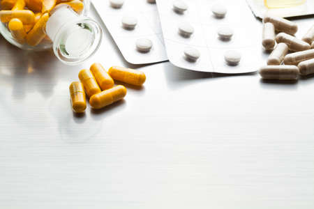 Medications as various capsules on a metal tableの写真素材