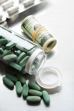 Dollar bills and pills as a symbol of pharmaceutical businessの写真素材