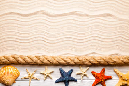 Beach background - starfish, shell, rope and wooden plank on sand backgroundの写真素材