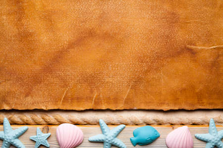 Blank handmade paper sheet and seashells on wooden and sand backgroundの写真素材
