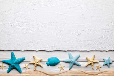 Seashells and sand on white plastered backgroundの写真素材