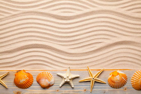 Marine symbols - beach sand and starfish and shell on old wooden plankの写真素材