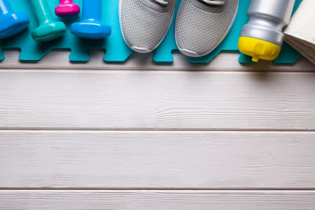 Symbols and metaphors of sport - fitness equipment on white wooden background