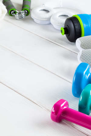 Sport and fitness symbols - sneakers, water and dumbbell on wooden wall backgroundの写真素材