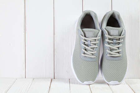 Sport symbols - gray sneakers on wooden wall backgroundの写真素材