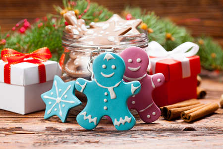 Colorful Christmas cookies and gift boxes in a jar and wooden tableの写真素材