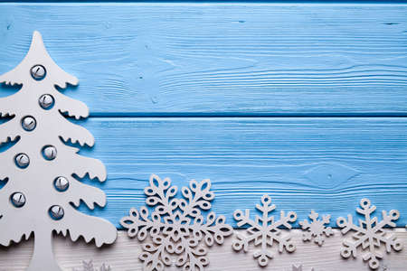 Christmas background - wooden tree and snowflakes on white and blue tableの写真素材