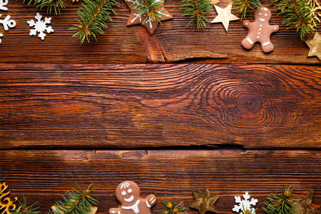 Christmas spruce tree, gingerbread cookies and decorations on wooden tableの写真素材