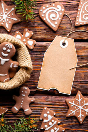 Christmas cookies, spruce tree and blank paper label on wooden backgroundの写真素材