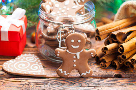Gingerbread Christmas cookies, gift box and spices on wooden tableの写真素材