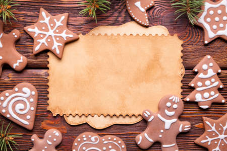 Christmas gingerbread cookies and blank paper sheet on wooden backgroundの写真素材