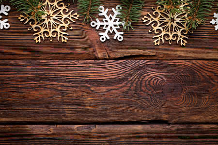 Christmas background - branch of spruce tree and wooden snowflakes on tableの写真素材