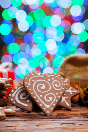 Gingerbread Christmas cookies on lighting background and wooden tableの写真素材