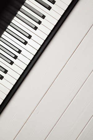 Piano keyboard on white woooden backgroundの写真素材