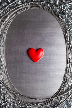 Small red heart on steel metal backgroundの写真素材
