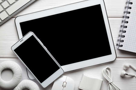 White modern digital tablet and smartphone, headphones, computer mouse and keyborad on white backgroundの写真素材