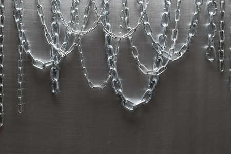 Metal chains on brushed aluminum backgroundの写真素材