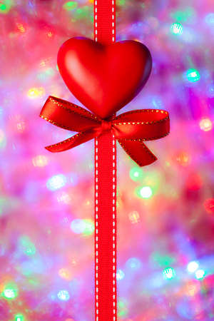Red heart, bow and ribbon on blurred abstract backgroundの写真素材