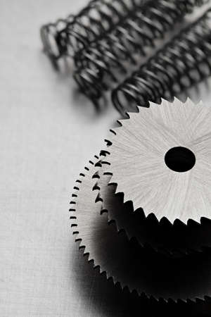 Circular saw discs and metal springs on an aluminum tableの写真素材