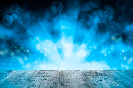 Wooden table with free space on blue abstract lighting backgroundの写真素材