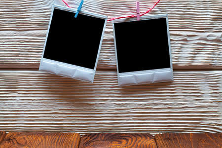 Vintage photo frames with empty spaces on wooden wall background and tableの写真素材