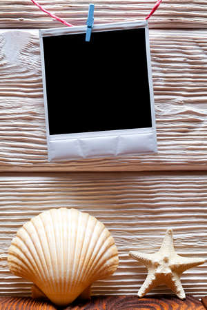 White vintage photo frame with empty space, shell and starfish on wooden backgroundの写真素材