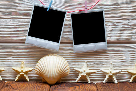 Two vintage photo frames with empty spaces and shells on wooden backgroundの写真素材