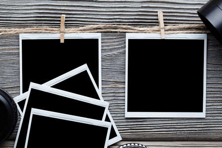 Photo frames and lenses on wooden boardの写真素材