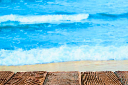 Wooden table with empty space on the beach backgroundの写真素材