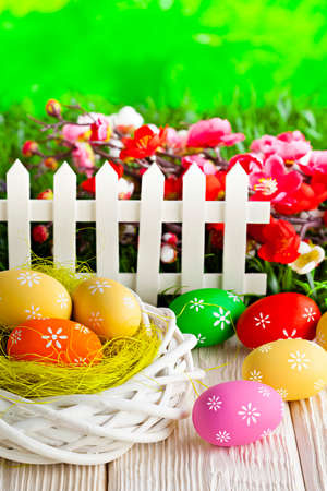 Colorful Easter eggs in the nest on wooden table and nature backgroundの写真素材