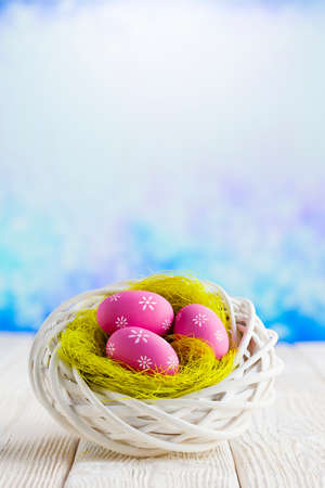 Easter eggs in the nest and wooden table on abstract backgroundの写真素材