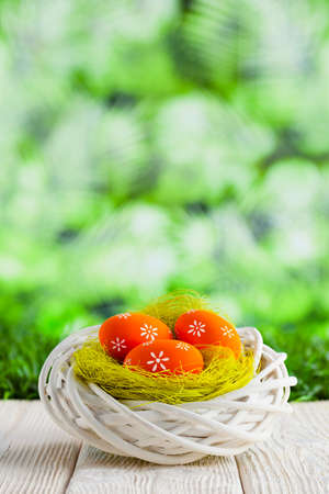 Easter eggs in the nest and wooden table on green abstract backgroundの写真素材