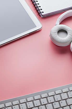 Mobile phone, computer keyboard, headphones and notebook on pink backgroundの写真素材
