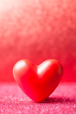 Red heart on red blurred abstract backgroundの写真素材
