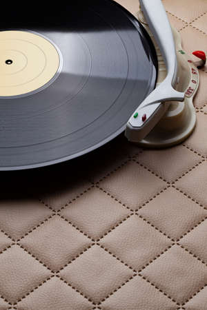 Retro vinyl player with classic vinyl record on leather backgroundの写真素材