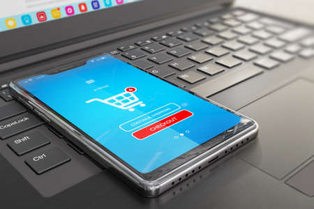 Smartphone with online store application on screen and laptop keyboard - symbol of e-commerce,...