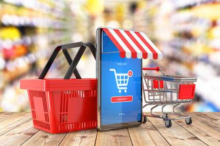 Shopping basket and shopping trolley cart. Cell phone with mobile e-shop application on screen as a online shopping symbol and supermarket interior in background - 3d illustrationの写真素材