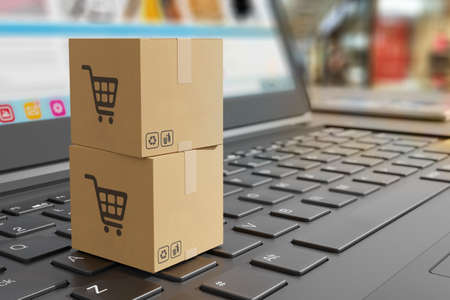 Two cardboard shipping boxes on laptop keyboard as symbol of shipping goods and online shopping - concept 3D illustrationの写真素材