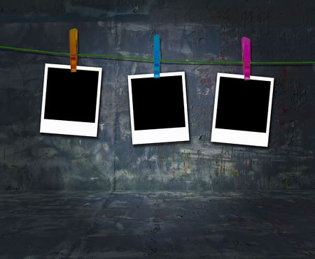 Blank Photos Hanging on a Clothes Line in Dark Grungy Roomの写真素材