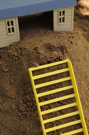 Toy House with Ladder on Sandの写真素材