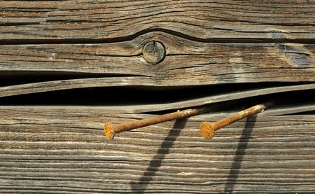 Rusty Nails in Cracked Wooden Plankの写真素材