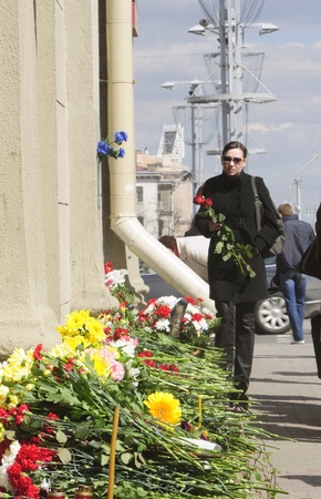 MINSK, BELARUS - APRIL 12, 2011: A woman brings flowers to Oktyabrskaya metro station after a terrorist attack on April 11, 2011 in Minsk, Belarusのeditorial素材