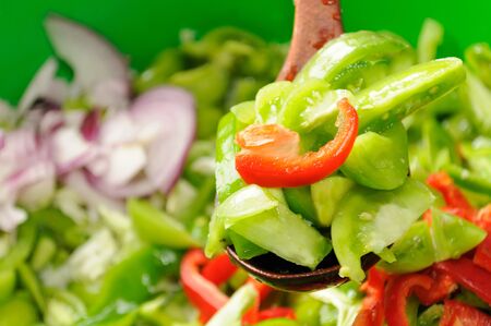 Green Tomato, Pepper and Onion Salad on Wooden Spoonの写真素材
