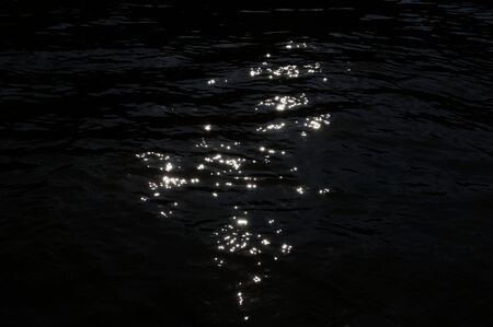 Ripples on dark water surface at nightの写真素材