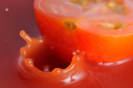 Tomato juice crown splash with tomato half close-upの写真素材
